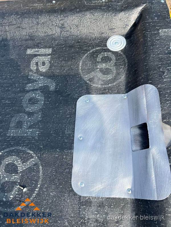 Dakdoorvoer met metalen afvoerplaat op bitumen dak in Bleiswijk