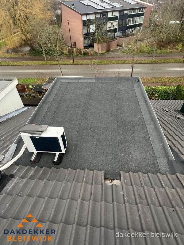 Plat dak inspectie met bitumen bedekking naast schuin pannendak in Bleiswijk Plat dak inspectie met bitumen bedekking naast schuin pannendak in Bleiswijk