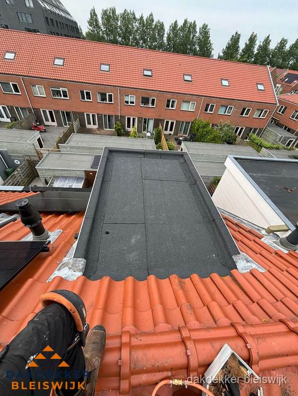Bitumen dak reparatie op plat dak tussen dakpannen in Bleiswijk