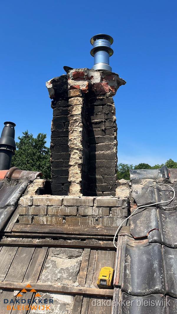 Beschadigde schoorsteen met nieuwe rookgasafvoer op oud dak in Bleiswijk