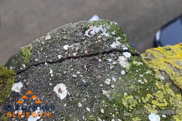 Beschadigde en verweerde nokvorst met scheuren en mos in Bleiswijk