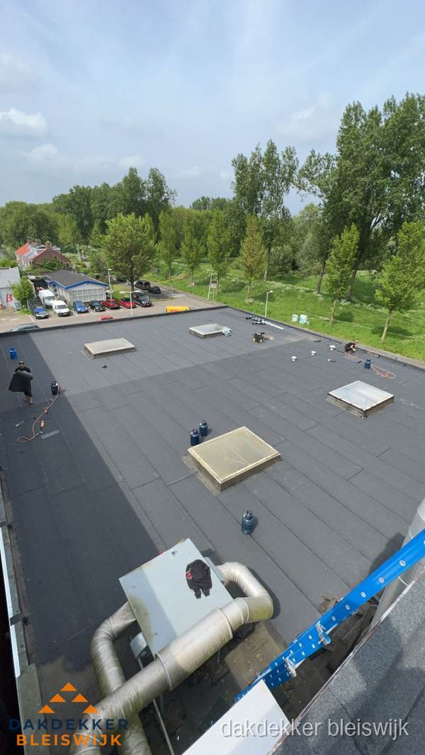 Dakdekker aan het werk op groot plat dak met bitumen in Bleiswijk Dakdekker aan het werk op groot plat dak met bitumen in Bleiswijk