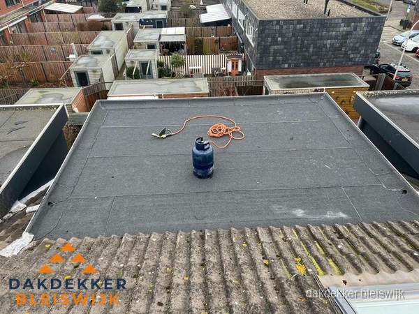 Plat dak met nieuwe bitumen dakbedekking en brandgereedschap in Bleiswijk